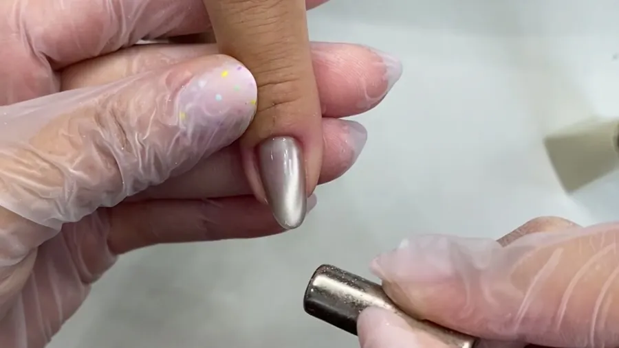 O ímã perto da ponta de uma unha com esmalte magnético.