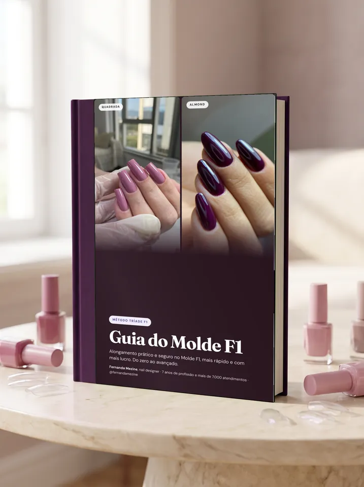 O Guia do Molde F1 impresso, em pé numa mesa de mármore, entre esmaltes rosa.