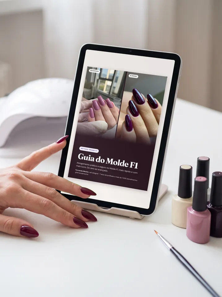 A capa do guia aberta num tablet, na mesa de atendimento, ao lado da cabine e dos esmaltes.